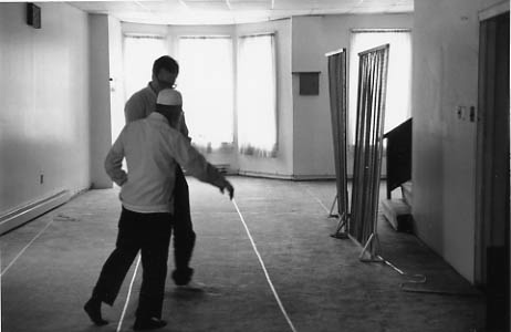 Interior of Sunnat-Ul-Jamaat mosque: The Imam points to masking tape lines that orient worshippers to Mecca.