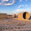 A photograph of the art installation, Sun Tunnels, which are comprised of large, concrete tubes with holes drilled to mimic constellations.