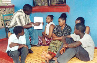 Several people sitting and listening to a counselor.