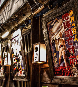 A photo of older movie posters outside of a wooden building.