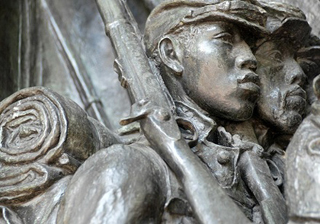 Photo of a metal relief sculpture of Civil War-era soldiers marching with rifles and gear.