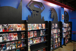 Black display shelves with a variety of comic books, each shelf adorned with a comic book symbol on top.