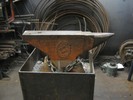 An orange Vulcan anvil, chained and bolted to a metal block.