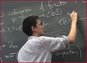 A men standing in front of a blackboard and writing on the blackboard.