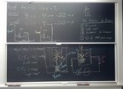 Photon interaction related equations on two blackboards.