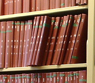 Photo of hardbound academic theses on library shelves.