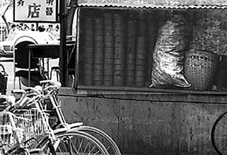 A photograph of coal briquettes stacked against a restaurant in Beijing, China.