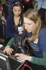 A woman is sitting at a computer with a boot.