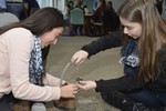 A girl and a woman are working together to attach electronic components to a shoe.